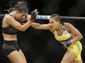 Amanda Nunes, right, hits Miesha Tate during their women's bantamweight championship mixed martial-arts bout at UFC 200, Saturday in Las Vegas. — The Associated Press