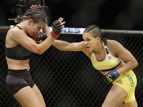 Amanda Nunes, right, hits Miesha Tate during their women's bantamweight championship mixed martial arts bout at UFC 200 last week in Las Vegas. Nunes upset Tate to become the champion, the third time the belt has changed hands in the past year.