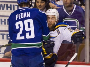 Vancouver Canucks' Andrey Pedan (29) checks St. Louis Blues' Alex Pietrangelo (27) during second period NHL hockey action in Vancouver on Saturday, March 19, 2016.