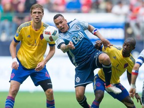 Vancouver Whitecaps' Blas Perez, centre, and Colorado Rapids' Micheal Azira, right, vie for the ball as Rapids' Axel Sjoberg looks on during first half MLS soccer action in Vancouver, B.C., on Saturday, July 9, 2016.