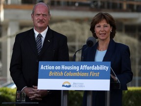 Premier Christy Clark and Finance Minister Michael de Jong, discuss amendments regarding housing issues in Greater Vancouver from the South lawn during a press conference at the Legislature in Victoria, B.C., Monday, July 25, 2016.