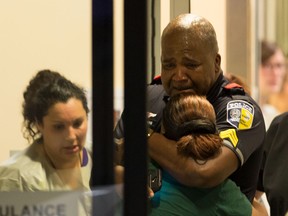 A Dallas Area Rapid Transit police officer receives comfort at the Baylor University Hospital emergency room entrance Thursday, July 7, 2016, in Dallas.