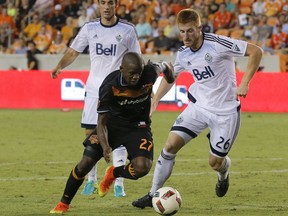 FILE - After claiming their first ever point in Texas with a 0-0 draw against the Houston Dynamo last weekend, the Vancouver Whitecaps look for their first win in the Lone Star State when they take on the more daunting FC Dallas. Houston Dynamo midfielder Oscar Garcia (27) dribbles around Vancouver Whitecaps defender Tim Parker (26) during second half MLS soccer action in Houston in a July 23, 2016 file photo.