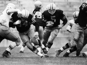 In this 1959 file photo, Paul Hornung (5) of the Green Bay Packers goes through the line in an inter-squad game in Green Bay, Wis. The Hall of Famer and former Heisman Trophy winner has sued equipment manufacturer Riddell Inc., saying football helmets he wore during his professional career in the 1950s and '60s failed to protect him from brain injury.