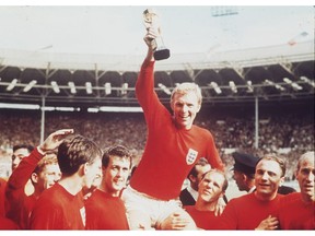 In this July 30, 1966 file photo England's soccer captain Bobby Moore, carried shoulder high by his team mates, holds aloft the FIFA World Cup. England defeated Germany 4-2 in the final, played at London's Wembley Stadium. From left to right, goalkeeper Gordon Banks (partially obscured), Alan Ball, Martin Peters, Geoff Hurst, Moore, Ray Wilson, George Cohen and Bobby Charlton.