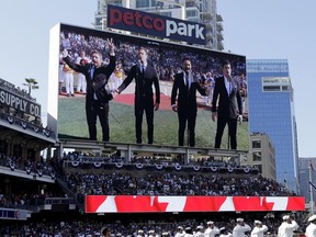 FILE - In this Tuesday, July 12, 2016 file photo, The Tenors, shown on the scoreboard, perform during the Canadian National Anthem prior to the MLB baseball All-Star Game, in San Diego. A member of a Canadian singing quartet changed a lyric in his country's national anthem and held up a sign proclaiming "All Lives Matter" during a pregame performance at the 87th All-Star Game on Tuesday. The Tenors, a group based in British Columbia, caused a stir at Petco Park with Remigio Pereira's actions while singing "O Canada."