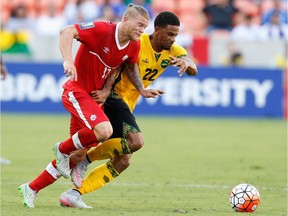 The Whitecaps' new defender/midfielder Marcel de Jong, left, is shown playing for Canada against Garath McCleary and Jamaica last summer.