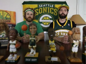 Jason Reid, left, director of the documentary film "Sonicsgate: Requiem for a Team," and producer Adam Brown, right, pose for a photo earlier this week with some of their Seattle SuperSonics memorabilia in Seattle. July 18, 2016 will mark 10 years since the Seattle SuperSonics NBA team – the city's first professional sports franchise – was sold by Starbucks CEO Howard Schultz and the Basketball Club of Seattle to Clay Bennett and the Professional Basketball Club LLC based in Oklahoma City.