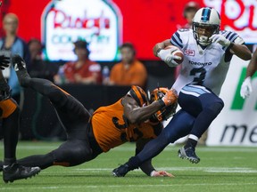 Argonauts' Brandon Whitaker, right, is brought down by B.C. Lions' Alex Bazzie.