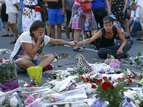 People pay tribute to victims at the site of the terrorist attack in Nice, France. 84 people were killed when a truck plowed through a crowd celebrating Bastille Day.