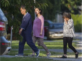 A possibly pregnant woman flanked by an older man and woman enter a property in the Blundell area of Richmond on June 30, 2016. A neighbour suspects the home is being operated as a birthing house for non-Canadian citizens aiming to have their children born here.