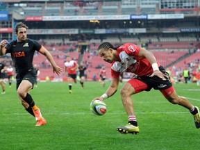 Courtnall Skosan (R) of Lions scores a try against Jaguares with Jaguares Nicolas Sanchez (L) looking on during the Super Rugby clash between Lions and Jaguares at Ellis Park rugby stadium in Johannesburg on May 21, 2016.  /