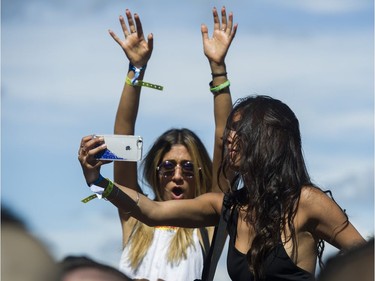 Two women sitting on shoulders take a selfie as Ekau performs at FVDED in the Park.