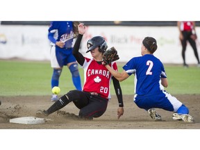 Canada's Megan Gurski has her helmet knocked askew as she slides safely into second base Thursday night against Italy at the women's world softball championship at Softball City in Surrey. Canada won 3-1.