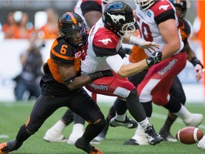 T.J. Lee, pictured (left) stripping the ball from Calgary Stampeders QB Bo Levi Mitchell in a June 25 game, has been lost to the B.C. Lions for the season with an Achilles rupture.
