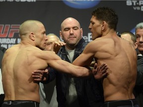 Fighters Georges St-Pierre, left, and Nick Diaz are separated during the weigh-in for UFC 158 in 2013. Having a superfight between the two at the Vancouver UFC event would add sizzle to an otherwise lackluster card.