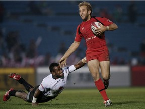 TOKYO, JAPAN - APRIL 05: Sean White #1 of Canada breaks the tackle of Jerry Tuwai #9 of Fiji during the Third Place Playoff match on day two of the Tokyo Sevens Rugby 2015 at Chichibunomiya Rugby Stadium on April 5, 2015 in Tokyo, Japan.