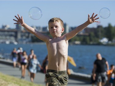 Jared Francis, age 4, chases bubbles as he waits for the fireworks display from team USA Disney at the Honda Celebration of Light.