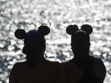 Kay Linan and Andrea Cabacungan wear Mickey Mouse ears as they wait for the fireworks display from team USA Disney at the Honda Celebration of Light.