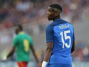 FILE - In this Monday, May 30, 2016 file photo, France&#039;s Paul Pogba looks on during a friendly soccer match between France and Cameroon at the La Beaujoire Stadium in Nantes, western France. Manchester United says Paul Pogba has been granted permission to have a medical examination to finalize his transfer to the English club from Juventus. United made the announcement in a one-line statement on Sunday, Aug. 7, 2016 under the hashtag ‚ÄúPogback.‚Äù (AP Photo/David Vincent, file)