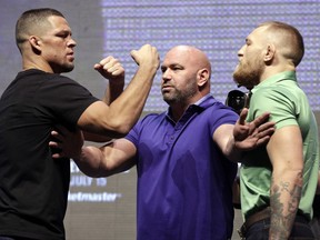 Dana White, center, stands between Nate Diaz, left, and Conor McGregor during a UFC 202 mixed martial arts news conference, Thursday, July 7, 2016, in Las Vegas. Diaz and McGregor are scheduled to fight at UFC 202 in Las Vegas.