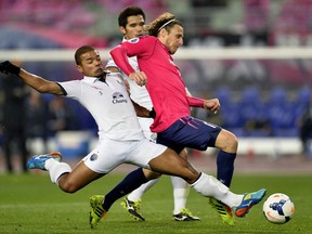 Cerezo Osaka's Diego Forlan of Uruguay, right, is challenged by Buriram United's Prathum Chutong in the Asian Champions League in Osaka, Japan, in 2014. Forlan was rumoured to be coming to Vancouver, but that's not to be the case. — The Associated Press files