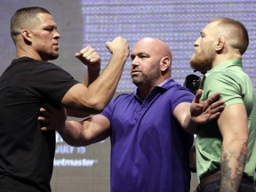 FILE - In this July 7, 2016, file photo, Dana White, center, stands between Nate Diaz, left, and Conor McGregor during a news conference in Las Vegas for UFC 202. Diaz beat McGregor by submission in the second round of a welterweight bout March 5 at UFC 196, ending McGregor's 15-fight winning streak. McGregor had asked for a quick rematch and it was scheduled during the landmark UFC 200 card in July, but McGregor announced he was retiring during the spring. He later relented, but by then UFC had dropped him from that card. Saturday's rematch was announced in June.