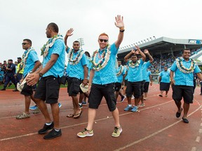 (FILES) This file photo taken on August 22, 2016 shows Fiji's rugby sevens coach Ben Ryan (C) waving to the crowd as he walks with his team during a victory ceremony at a stadium in Suva, upon their arrival from Brazil following the Rio Olympics.  Fiji has ramped up overtures August 30, 2016 to sevens coach Ben Ryan giving him land and a chiefly title to keep the popular Englishman in the South Pacific island nation. Ryan has become the most venerated person in Fiji since guiding them to their first Olympic medal when they won the sevens gold in Rio earlier this month.   /