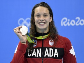 Canada's Penny Oleksiak celebrates on the podium after she won silver in the Women's 100m Butterfly Final during the swimming event at the Rio 2016 Olympic Games at the Olympic Aquatics Stadium in Rio de Janeiro on August 7, 2016.   / AFP / CHRISTOPHE SIMON        (Photo credit should read CHRISTOPHE SIMON/AFP/Getty Images)
