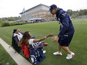Seattle Seahawks' Jimmy Graham, right, greets Ciara Wilson, wife of quarterback Russell Wilson, and Tammy Wilson, left, the quarterback's mother, as they look on during the team's NFL football training camp Saturday, July 30, 2016, in Renton, Wash.