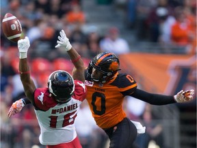 B.C. Lions' Loucheiz Purifoy, right, breaks up a pass intended for Calgary Stampeders' Marquay McDaniel.
