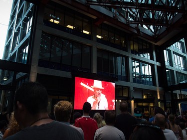 Lead singer Gord Downie is seen performing on a screen as people watch during a viewing party for the final stop in Kingston, Ont., of a 10-city national concert tour by The Tragically Hip, in Vancouver, B.C., on Saturday August 20, 2016. Downie announced earlier this year that he was diagnosed with an incurable form of brain cancer. THE CANADIAN PRESS/Darryl Dyck ORG XMIT: VCRD118