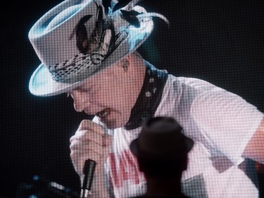 Lead singer Gord Downie is seen performing on a screen as a man watches during a viewing party for the final stop in Kingston, Ont., of a 10-city national concert tour by The Tragically Hip, in Vancouver, B.C., on Saturday August 20, 2016. Downie announced earlier this year that he was diagnosed with an incurable form of brain cancer. THE CANADIAN PRESS/Darryl Dyck ORG XMIT: VCRD106