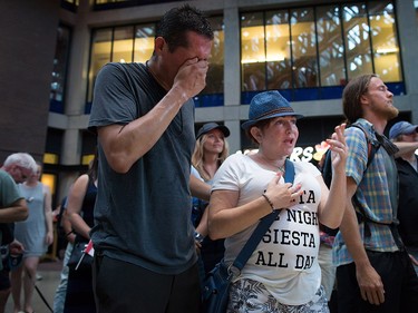 Friends, Steven Seegerts, left, and Elizabeth Robson, centre, attend a viewing party for the final stop in Kingston, Ont., of a 10-city national concert tour by The Tragically Hip, in Vancouver, B.C., on Saturday August 20, 2016. Lead singer Gord Downie announced earlier this year that he was diagnosed with an incurable form of brain cancer. THE CANADIAN PRESS/Darryl Dyck ORG XMIT: VCRD124