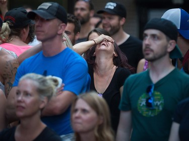 A woman, centre, reacts during a viewing party for the final stop in Kingston, Ont., of a 10-city national concert tour by The Tragically Hip, in Vancouver, B.C., on Saturday August 20, 2016. Lead singer Gord Downie announced earlier this year that he was diagnosed with an incurable form of brain cancer. THE CANADIAN PRESS/Darryl Dyck ORG XMIT: VCRD126