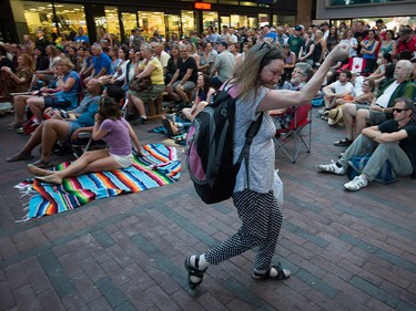 A woman dances as people gather for a viewing party for the final stop in Kingston, Ont., of a 10-city national concert tour by The Tragically Hip, in Vancouver, B.C., on Saturday August 20, 2016. Lead singer Gord Downie announced earlier this year that he was diagnosed with an incurable form of brain cancer. THE CANADIAN PRESS/Darryl Dyck ORG XMIT: VCRD110