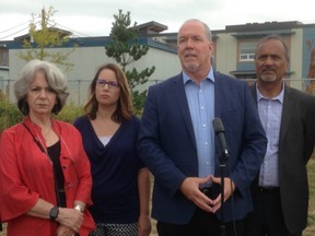 B.C. NDP leader John Horgan (centre, at microphone), speaks to reporters about overcrowding and portable classrooms in Surrey.