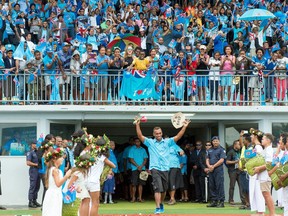 Rio Olympic gold medalist Fiji rugby sevens team members enter in a stadium in Suva upon their arrival from Brazil on August 22, 2016. Tens of thousands of Fijians cheered and many openly wept as they braved heavy rain to attend a victory ceremony in the capital Suva with celebrations rolling through a second day since the team returned home.  /