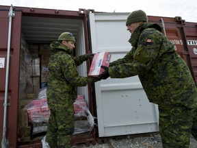 Members of 1 Platoon lend a hand unloading sea containers containing food and household supplies for the year in Resolute Bay, Nunavut.