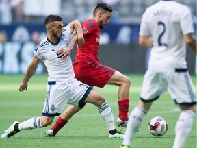 Vancouver Whitecaps midfielder Russell Teibert (left) tries to tie up Toronto FC's Jonathan Osorio during their Amway Canadian Championship final at BC Place Stadium in late June. Teibert pulled a quadriceps muscle during the series, putting another wrench in his 2016 season.