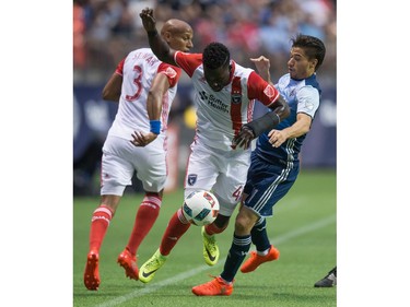 San Jose Earthquakes' Simon Dawkins, centre, and Vancouver Whitecaps' Nicolas Mezquida collide during the first half of an MLS soccer game in Vancouver, B.C., on Friday August 12, 2016.