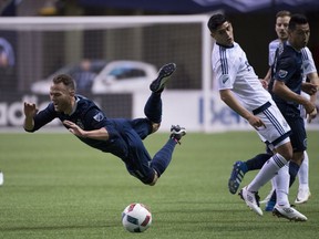 Sporting Kansas City midfielder Brad Davis (11) falls as he tries to gain control of the ball during the second half of MLS soccer action against the Vancouver Whitecaps FC in Vancouver, B.C. Wednesday, April 27, 2015.