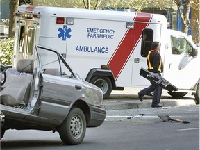 An ambulance attends a car accident on Burrard near Dunsmuir streets. Doesn't matter the time of day, the traffic or the weather, when drivers hear a siren they react most often in a manner that is uniform and kind: They get out of the way, writes columnist Wayne Moriarty. — Bill Keay files