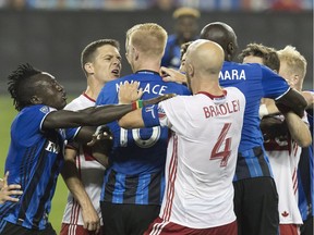 Toronto FC's Will Johnson, second from left, and Montreal Impact's Calum Mallace exchange words at midfield as team mates try to pull them apart during first half MLS soccer action in Toronto on Saturday, August 27, 2016.