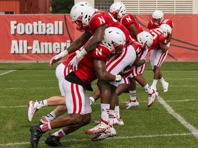 In this Aug. 9, 2016, photo, Nebraska's Tre Bryant, front left, and Nebraska's Tyrin Ferguson , front right, practice rugby-style tackling during NCAA college football team practice in Lincoln, Neb. Nebraska is the latest program to adopt rugby-style tackling where the tackle is made by driving a shoulder into the ball-carrier's near hip, wrapping him up and taking him to the ground. All the while the defender's head is kept to the side of the ball-carrier's body, away from the tackle contact zone.