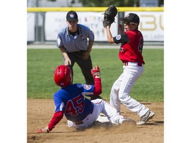 Whalley Little League #45 Ethan Hein slides into second base defended by Moose Jaw Little League #4 Kaedyn Banilevic at the Canadian Little League Championship