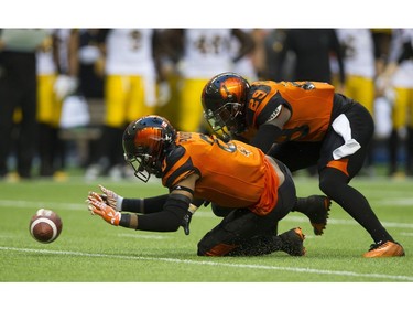 BC Lions #0 Loucheiz Purifoy and #29 Steven Clarke scramble for a loose ball that popped away after Hamilton Tiger-Cats #4 Zach Collaros was sacked.