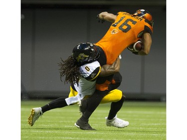 BC Lions #16 Bryan Burnham is tackled by Hamilton Tiger-Cats  #0 Rico Murray.