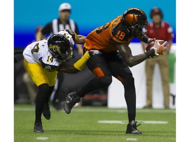 BC Lions #18 Geraldo Boldewijn is tackled by Hamilton Tiger-Cats  #14 Travis Lee.