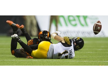 BC Lions #28 Anthony Thompson and Hamilton Tiger-Cats  #17 Luke Tasker hit the field after a loose ball.